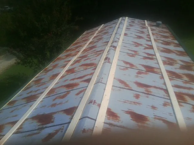 Rusted metal roof panels with new wood purlins before replacement — Storm Damage Roof Repair in Elma by Roofing Brothers
