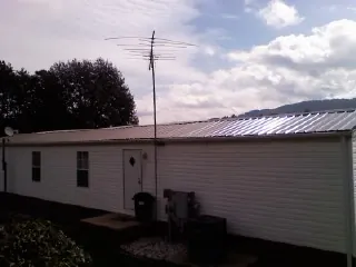 New metal roof on a single wide mobile home with a TV antenna in Elma